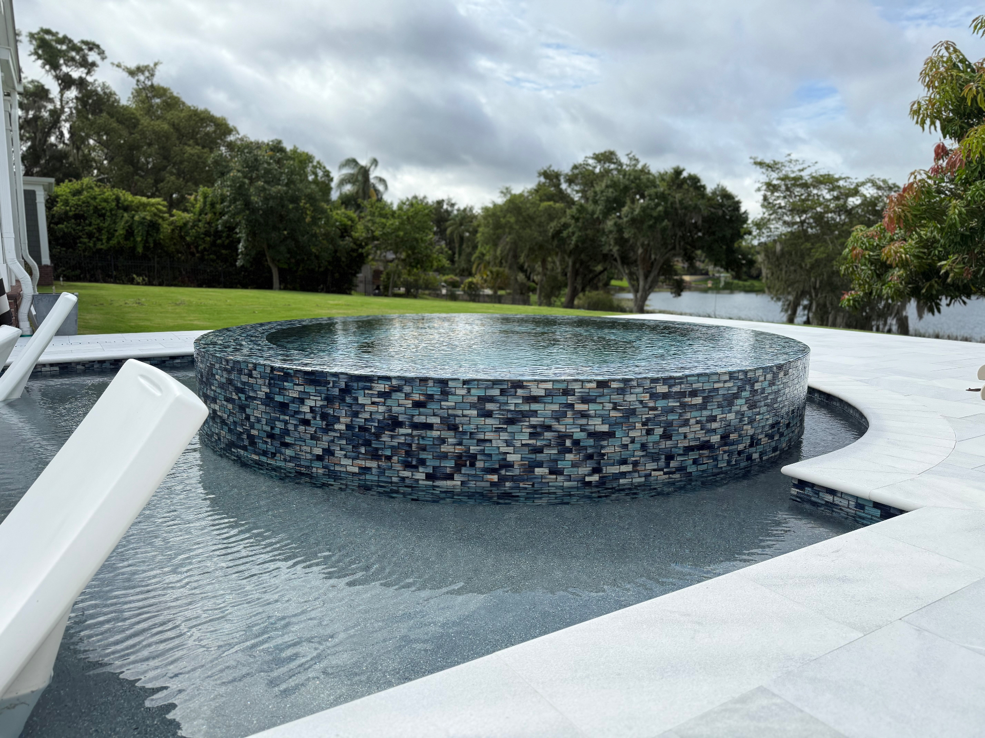Raised mosaic-tiled spa spilling into the Berry House pool