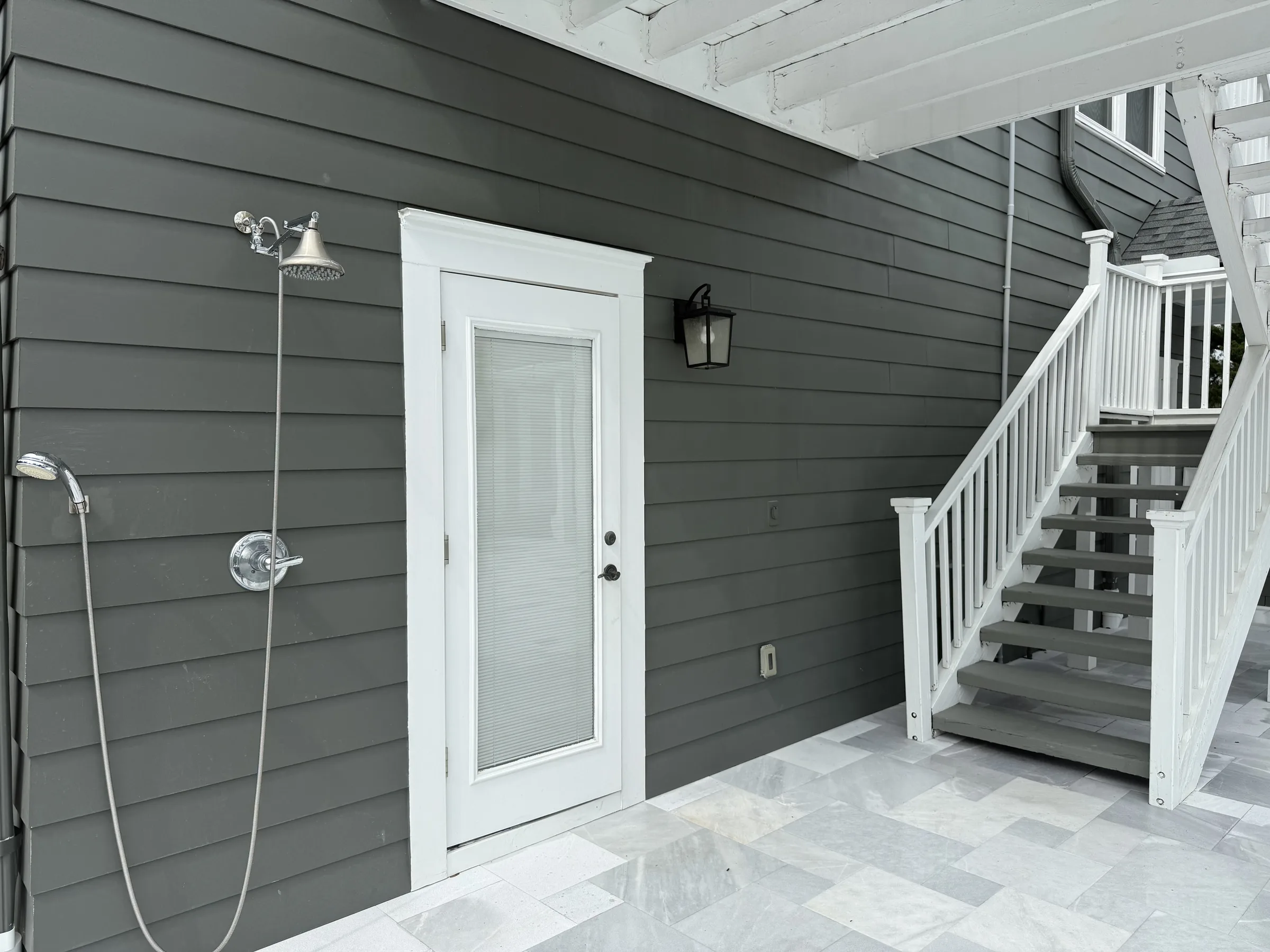 Pool bathroom, outdoor shower, and stairs beside the guest apartment